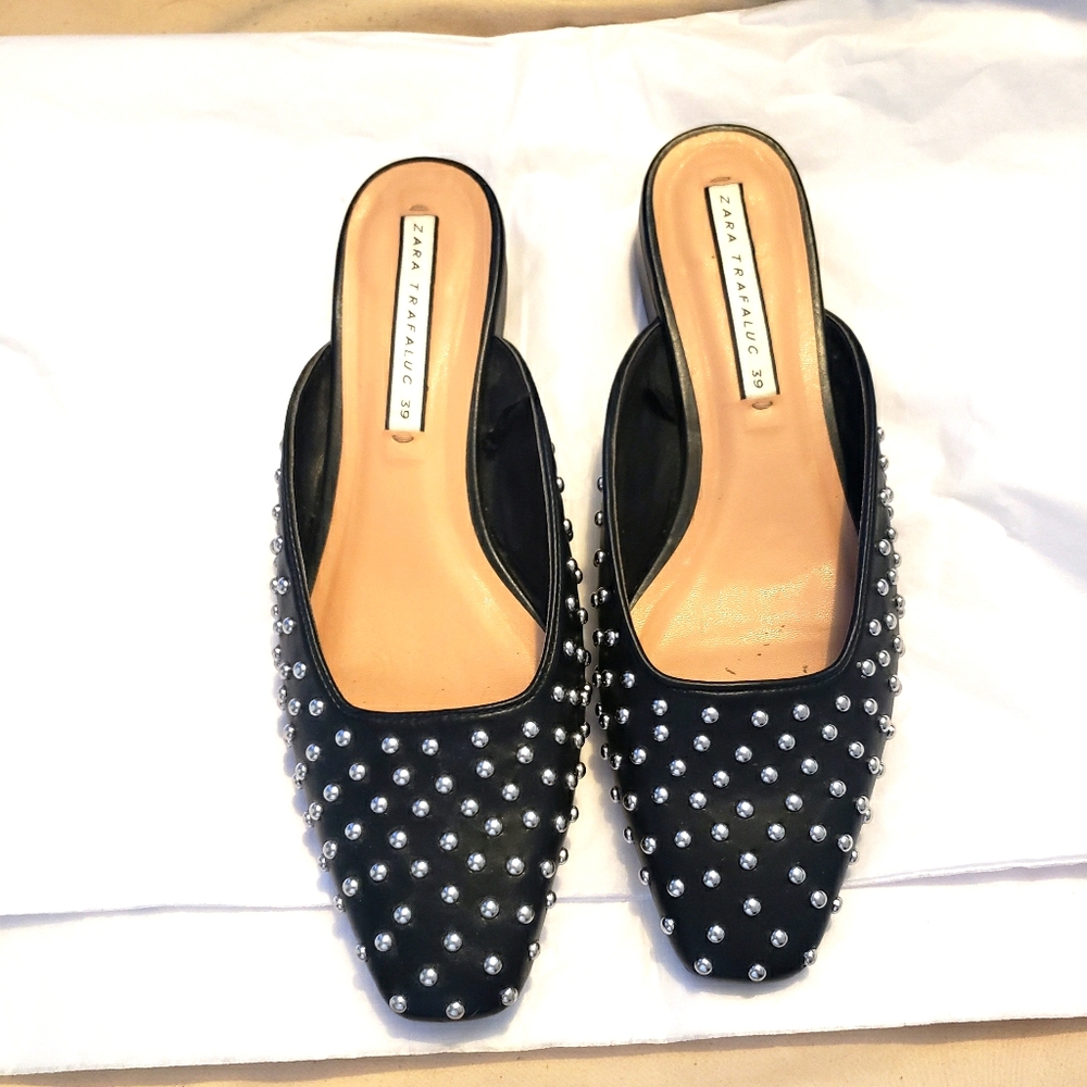 Black flat slides with silver studs.